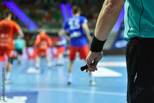 Fototapeta Naklejka Na Ścianę i Meble -  Handball referee hand with whistle