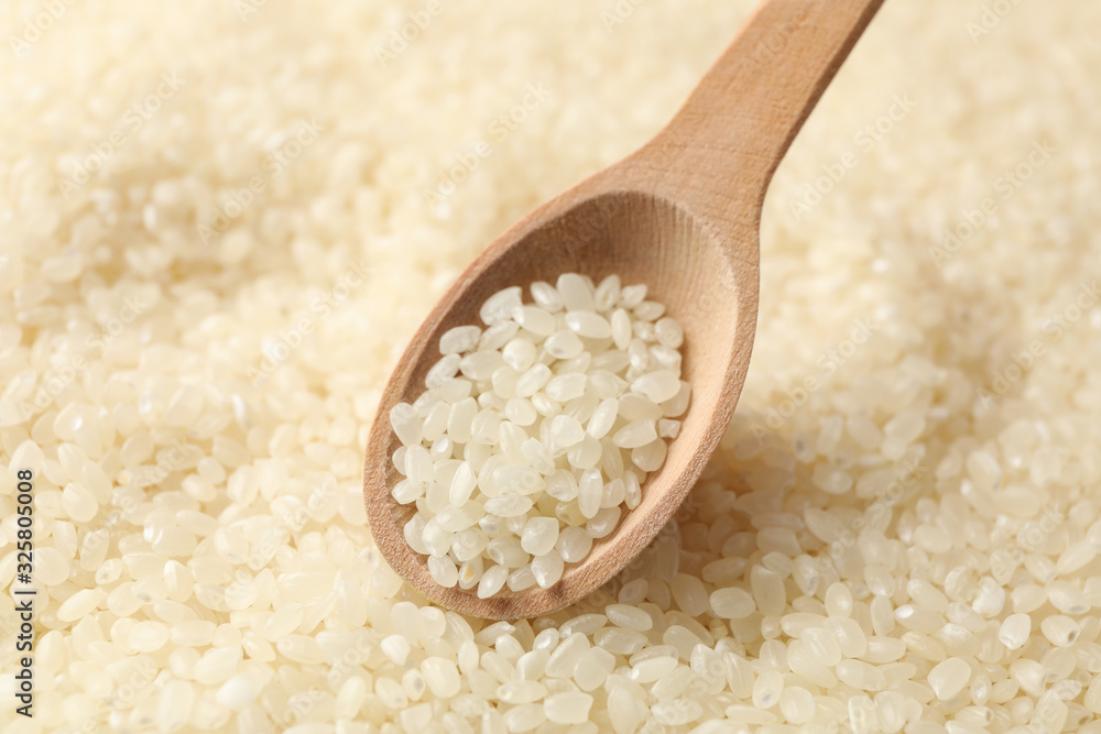 Rice background and wooden spoon, close up Rice background and wooden spoon, close up
