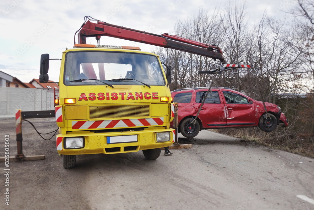 Assistance car lifts and loads a car after an accident. Tow truck with
