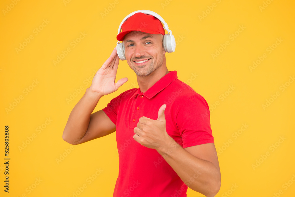 Audio guide. Man in headphones on yellow background. Assistant call center help find solution. Guy call service worker. Man listen music headphones. Incoming call. Worker in uniform with earphones