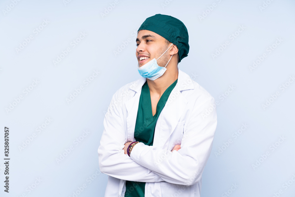 Surgeon man with uniform isolated on blue background laughing Surgeon man with uniform isolated on blue background laughing
