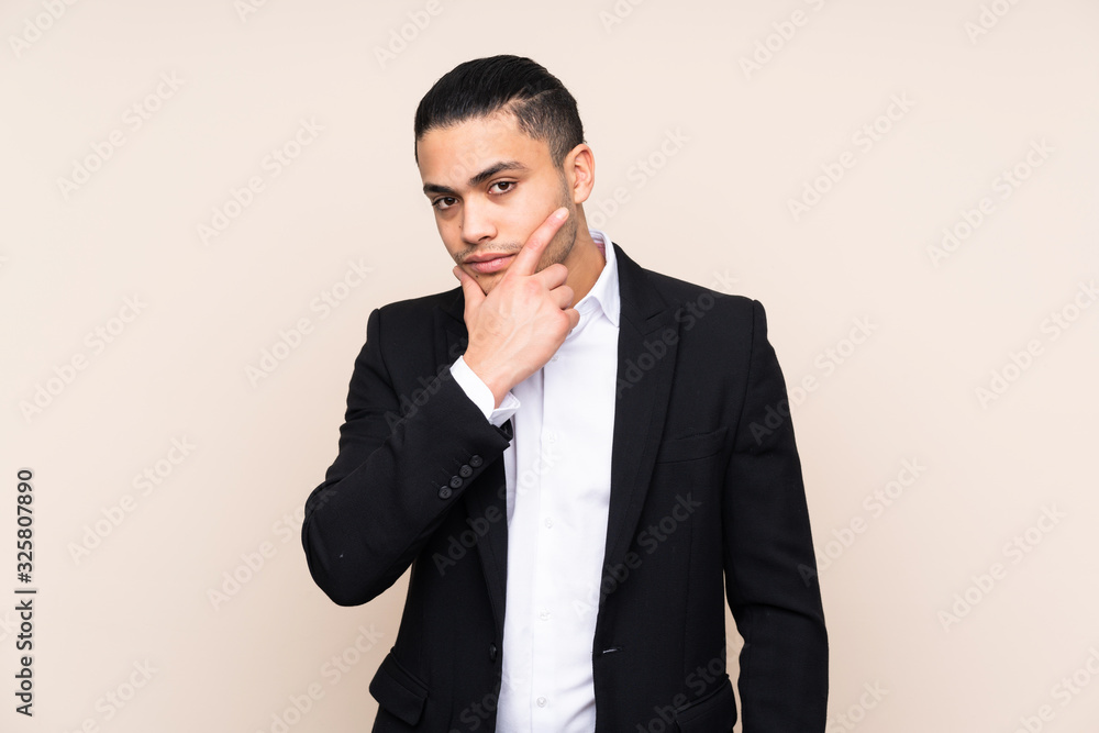 Asian business man isolated on beige background thinking an idea Asian business man isolated on beige background thinking an idea