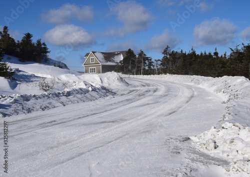 snow covered curved road after snow plow has passed in an rural area