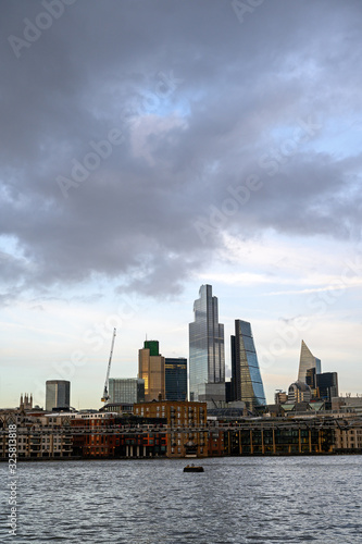 City of London in the UK. Landscape view over the River Thames to the city of London. Cityscape of the business district with skyscrapers, dramatic clouds and river in London, England 2020. © Jonathan Wilson