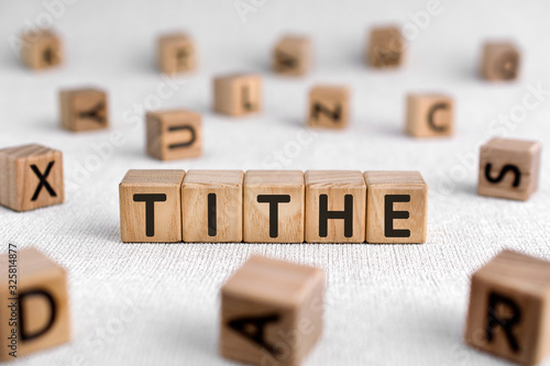Tithe - words from wooden blocks with letters, one-tenth part tax to the Church tithe concept, white background photo