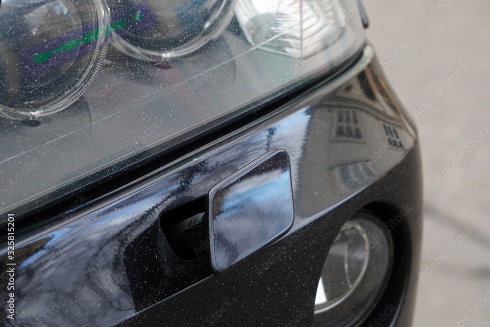 Obraz premium Headlight washer system of the black car. The headlight washer is broken, not working. Breakdown of the car's washing system
