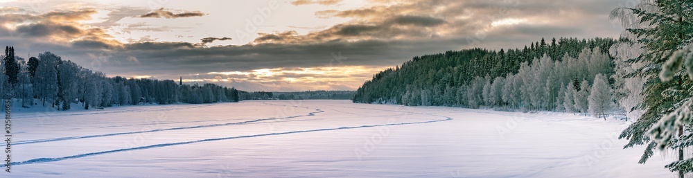 Sunset panorama over winter forest at sides and frozen river in the middle. Typical Northern Sweden landscape - birch and spruce tree covered by hoarfrost - very cold day, Lappland, Sweden Sunset panorama over winter forest at sides and frozen river in the middle. Typical Northern Sweden landscape - birch and spruce tree covered by hoarfrost - very cold day, Lappland, Sweden