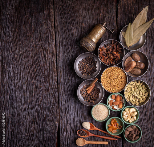 Set of various spices on rustic wood background. Pepper, turmelic, paprika, basil, rosemary, chilly, cardamom, cinnamon, anise. Top view with copy space.