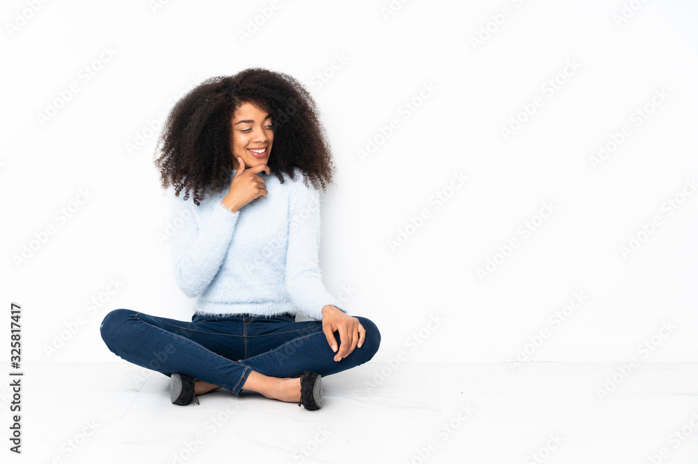 Young african american woman sitting on the floor looking to the side Young african american woman sitting on the floor looking to the side