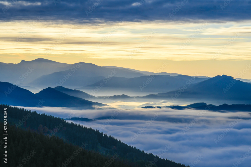 Fototapeta premium Zalla Valley covered with fog with Mount Gorbea at sunrise