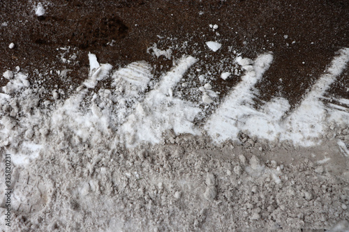 The texture of snow and frozen sand. Snow on the footpath