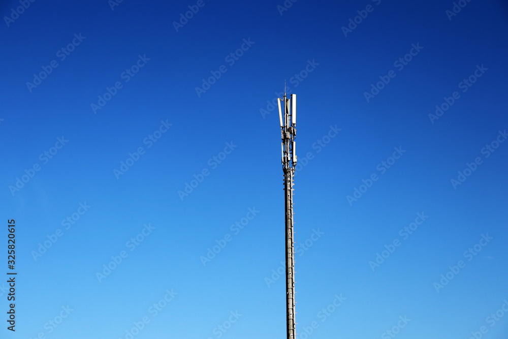 Mobile communications tower on a background of blue sky. Technological pillar and sky. Antenna Mobile communications tower on a background of blue sky. Technological pillar and sky. Antenna