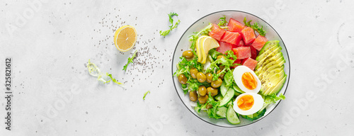 Ketogenic, keto or paleo diet lunch bowl with salted salmon fish, lemon, avocado, olives, boiled egg, cucumber, green lettuce salad and chia seeds. Healthy food trend. Top view. Banner