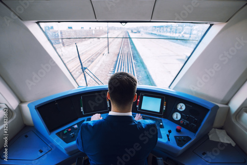 Fotografia Shot of train cockpit interior with driver sitting and driving train