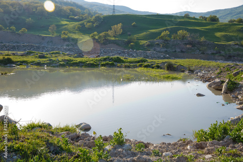 Lake in Xizi . Amazing landscape of lake with crystal clear green water and blue sky. Panoramic view of beautiful mountain landscape . Green mountains in Xizi, Azerbaijan .