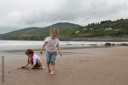 Children play on the coast of the Atlantic Ocean, family holidays in Ireland, Inch Beach, County Kerry Ireland