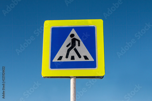 Pedestrian crossing ahead road sign in Russia against a blue sky