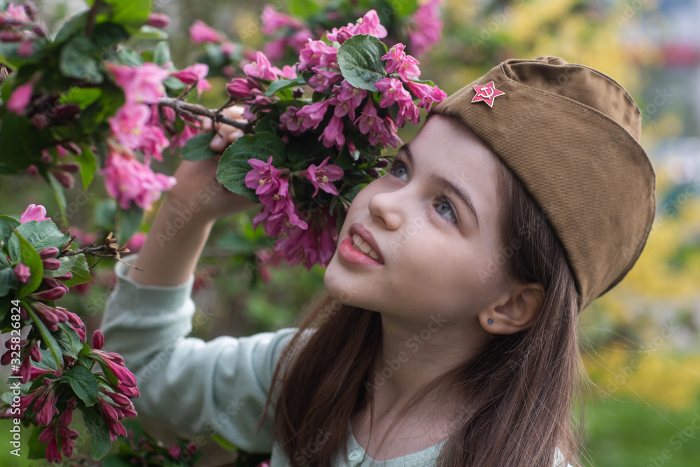 Beautiful girl in uniform with flowers at the celebration of Victory Day in World War II. May 9 in Russia. Beautiful girl in uniform with flowers at the celebration of Victory Day in World War II. May 9 in Russia.