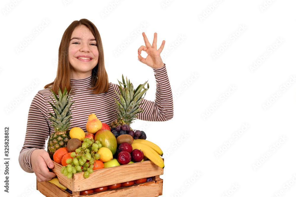happy girl holds wooden crate with fruits and shows ok hand sign happy girl holds wooden crate with fruits and shows ok hand sign