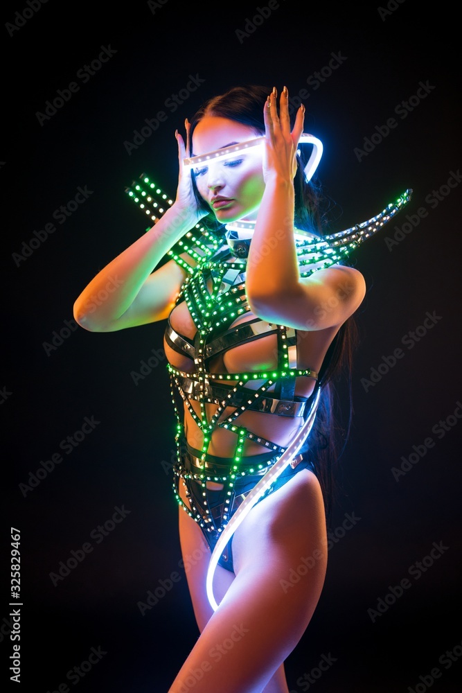 Girl in fantastic bdsm lingerie and uv lights shot Photos | Adobe Stock