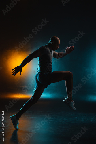 Dark studio photo of sportsman in motion stock photo
