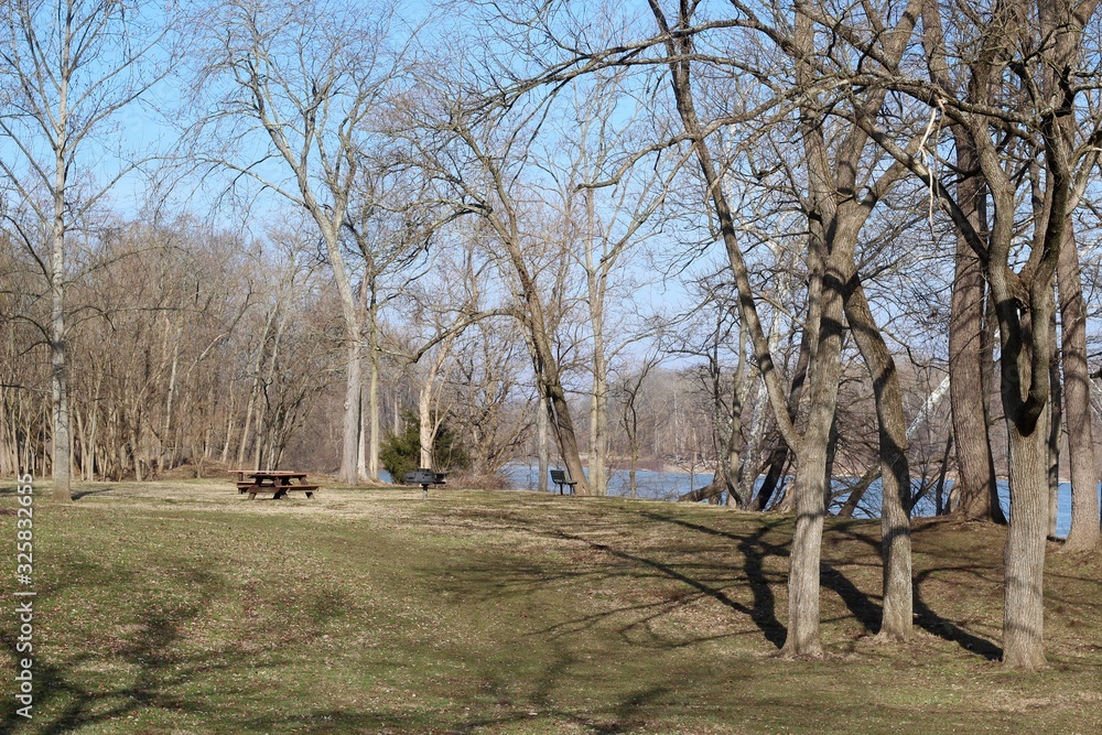 The empty picnic area near the river in the park.