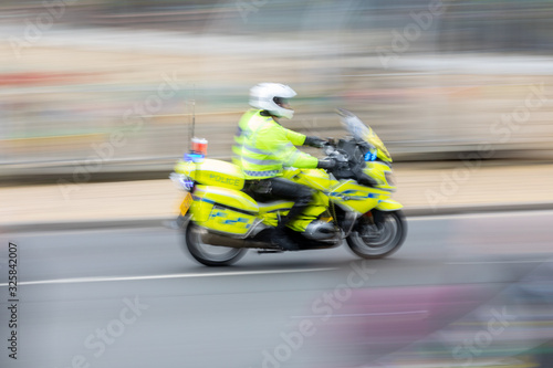 British police motorcyclist moving at speed © sjm3