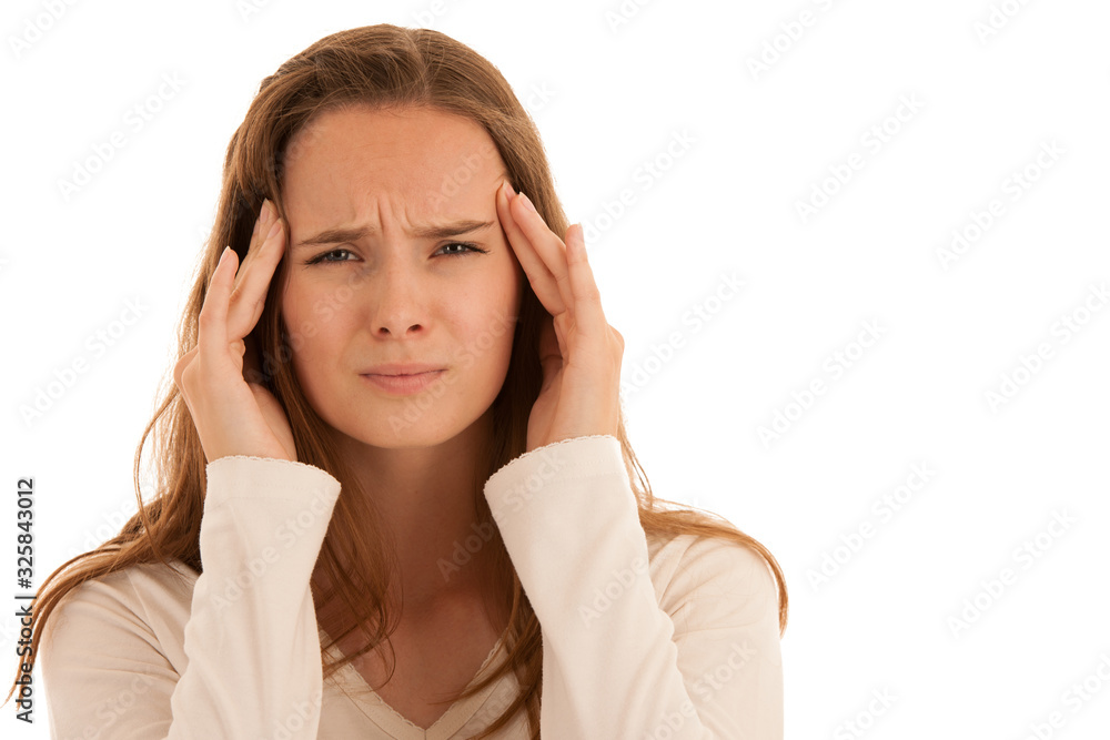 Beautiful young brunette woman holds her head as she has headache - illness Beautiful young brunette woman holds her head as she has headache - illness