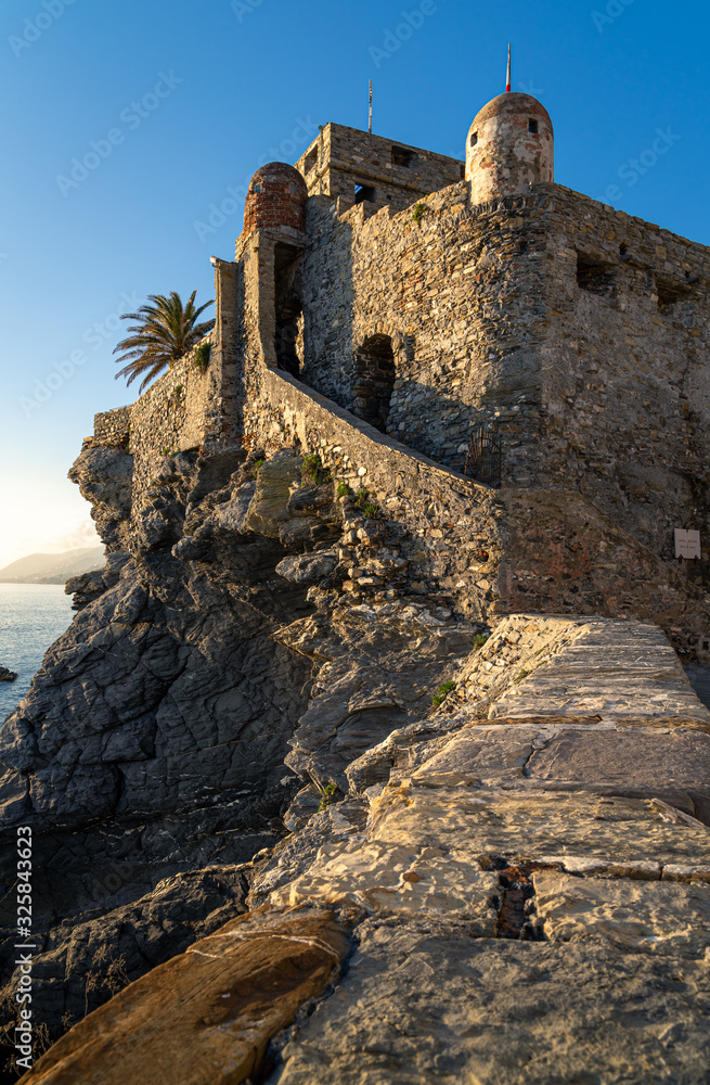 Camogli, Genoa, Italy. Dragonara castle walls with sunset lights