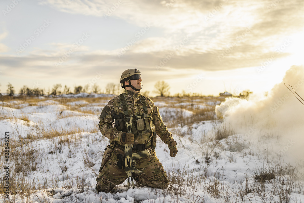 exhausted soldier man after battle fells to knees or kneeling in winter desert. commandos with equipment . Modern warfare battlefield soldier is on his knees and looking to sky exhausted soldier man after battle fells to knees or kneeling in winter desert. commandos with equipment . Modern warfare battlefield soldier is on his knees and looking to sky