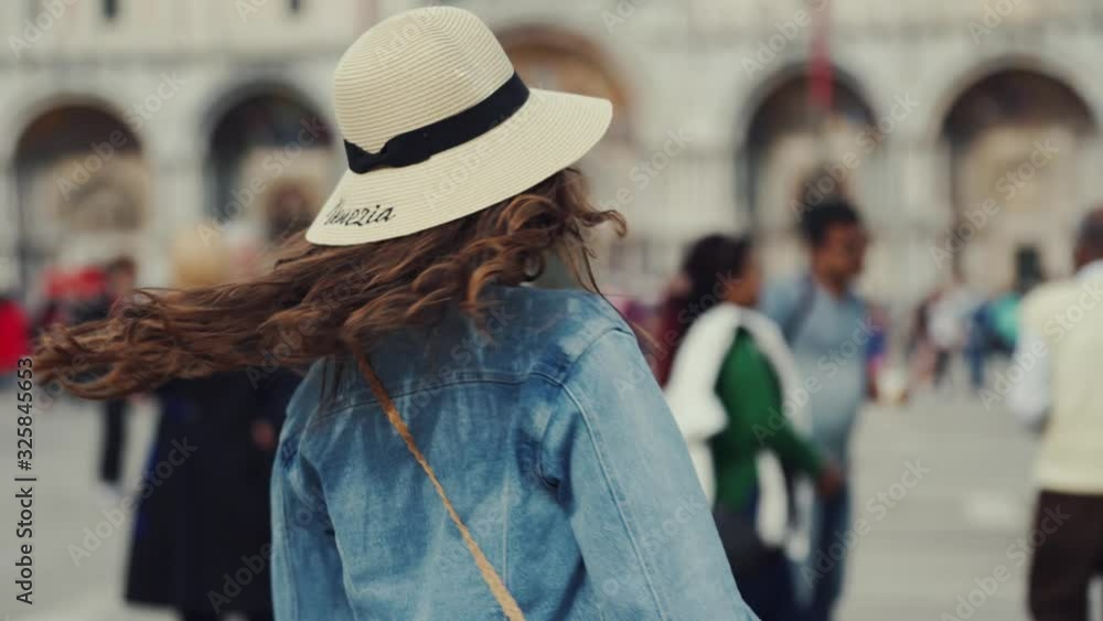 Brunette girl puts straw hat on head, turns around with smile, begins to whirl Brunette girl puts straw hat on head, turns around with smile, begins to whirl
