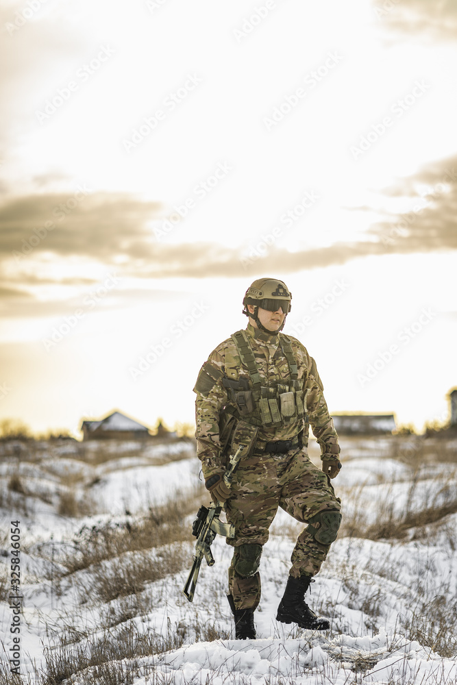exhausted army soldier Man in multicam camouflage after the battle walks in winter desert. commandos with full equipment helmet and gun watch battlefield. Modern warfare army soldier and battlefield exhausted army soldier Man in multicam camouflage after the battle walks in winter desert. commandos with full equipment helmet and gun watch battlefield. Modern warfare army soldier and battlefield