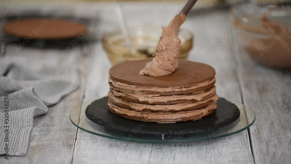 Step by step. Pastry chef making chocolate layer cake with prune filling. Confectioner puts cream on top of cake. Step by step. Pastry chef making chocolate layer cake with prune filling. Confectioner puts cream on top of cake.