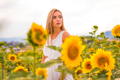 Rural Lifestyle, a young blonde in a field of sunflowers looking to the right