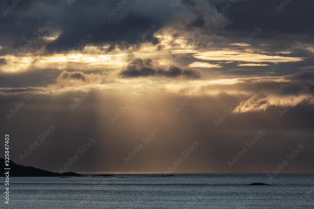 Sonnenstrahlen brechen duch dunkle Wolken über dem Atlantik vor Norwegen. - obrazy, fototapety, plakaty 