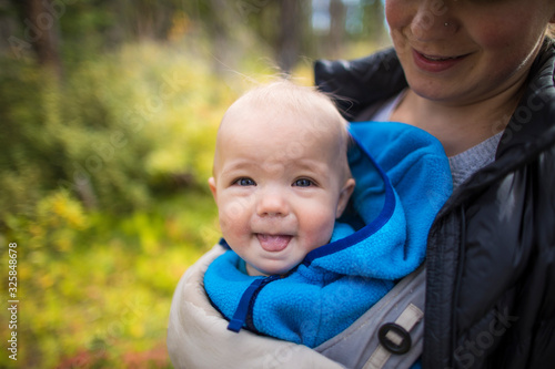 Portrait of mother holding baby in a front carrier. photo