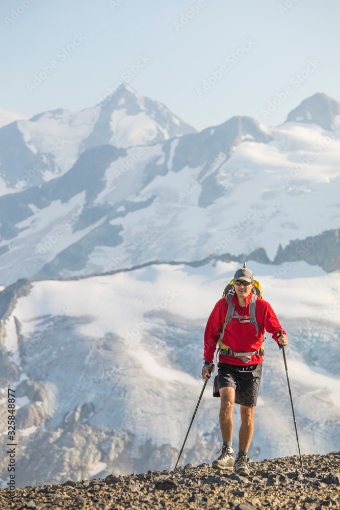 Backpacker hikes across talus slope in B.C. Canada. Backpacker hikes across talus slope in B.C. Canada.