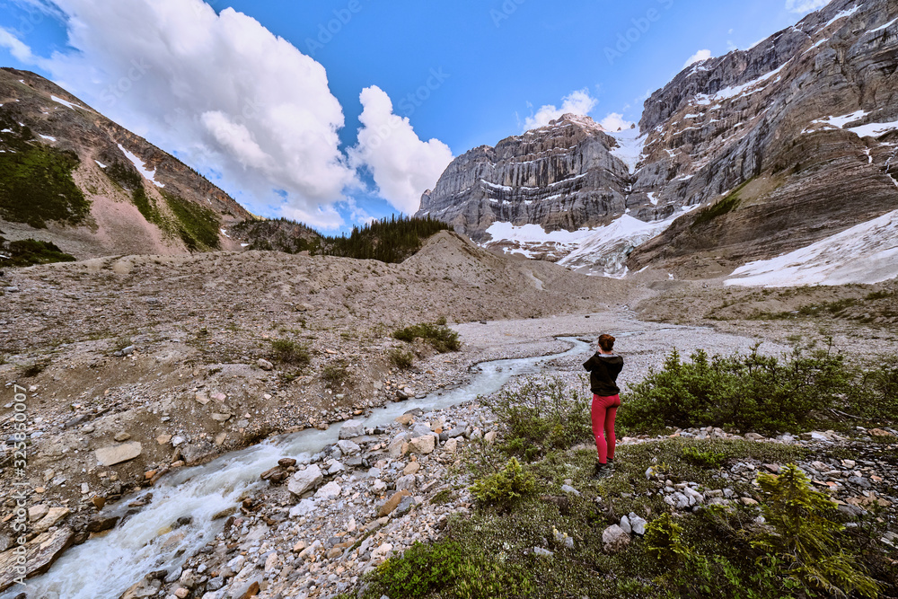 A woman stops to take a photo of glacial runoff above Cirque Lake. A woman stops to take a photo of glacial runoff above Cirque Lake.