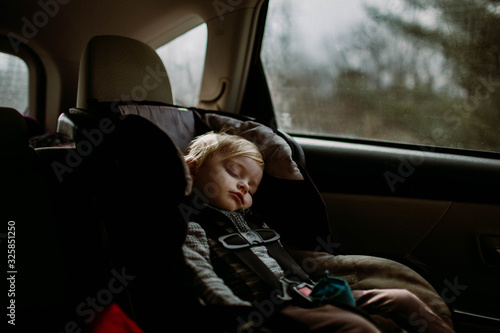 toddler asleep in carseat on road trip photo