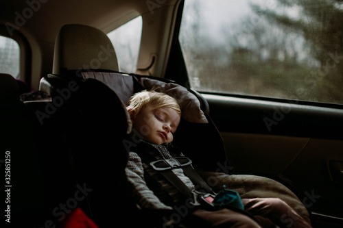 toddler asleep in carseat on road trip