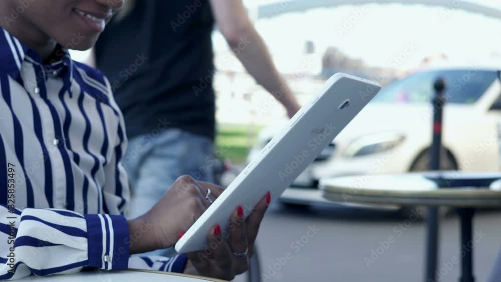 Woman reading something on tablet in cafe, focus on hands, 4K Woman reading something on tablet in cafe, focus on hands, 4K