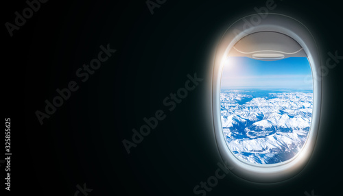 Black background with copy space with look of window frame of airplane flight see view of sunset clouds  airplane wing  ice mountains for luxury trip tourism travel transportation concept
