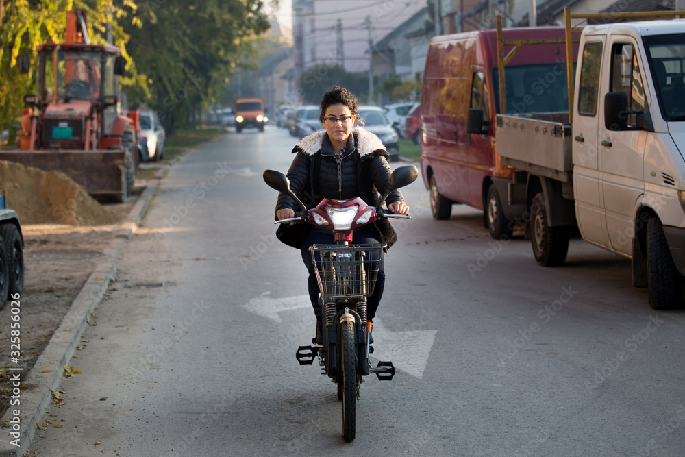 Woman riding electric bike on street