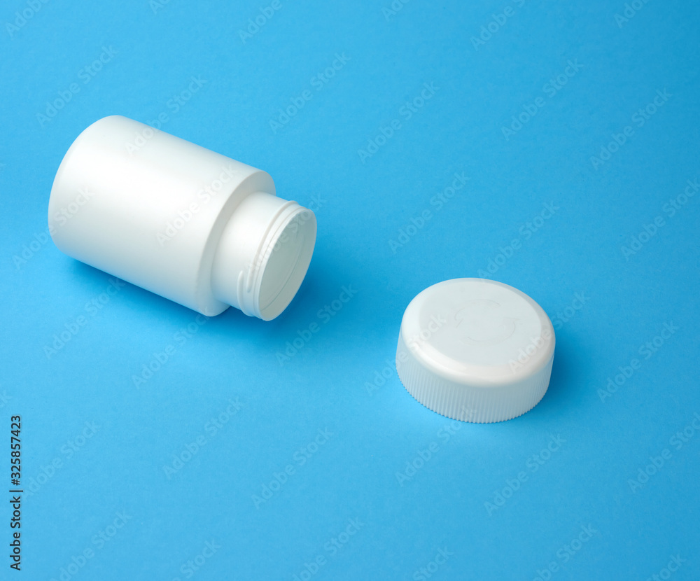 open empty white plastic container for pills lies on a blue background open empty white plastic container for pills lies on a blue background