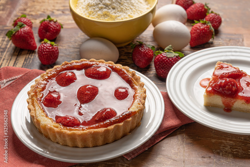 Homemade strawberry pie with and a golden crust, on wooden background