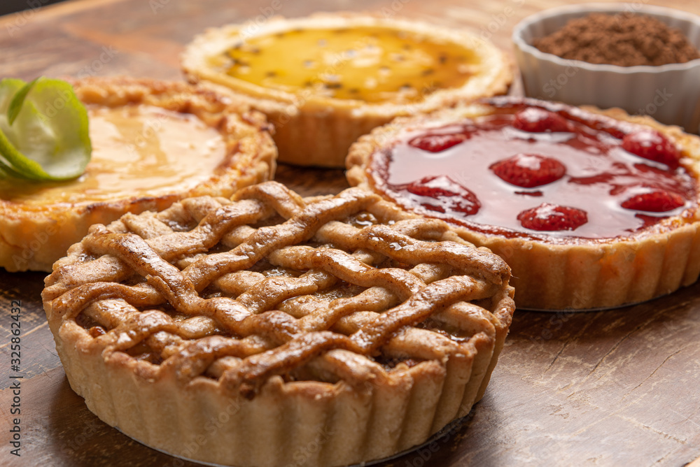 Assortment of homemade pies with and a golden crust, on wooden background Assortment of homemade pies with and a golden crust, on wooden background