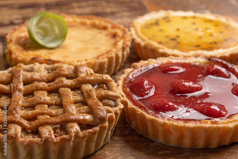 Assortment of homemade  pies with and a golden crust, on wooden background