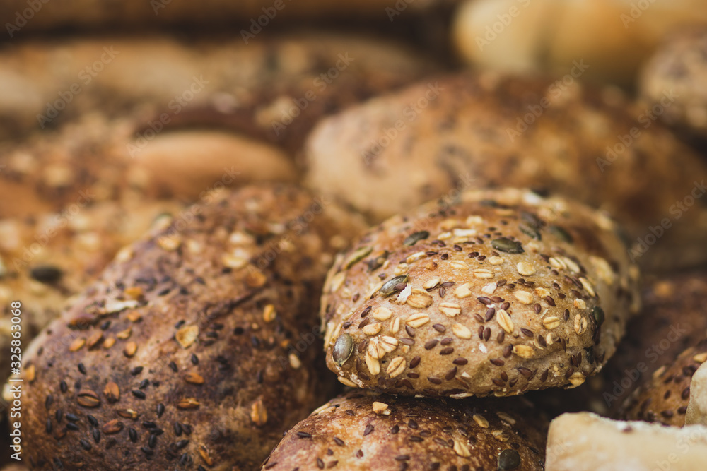 A pile of fresh baguettes made from whole flour. Coated with oats and sunflower seeds. Crispy, blurred background. The Market, Jerusalem. A pile of fresh baguettes made from whole flour. Coated with oats and sunflower seeds. Crispy, blurred background. The Market, Jerusalem.