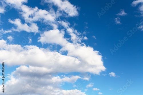 Beautiful white soft fluffy clouds on a blue sky background. Copy space