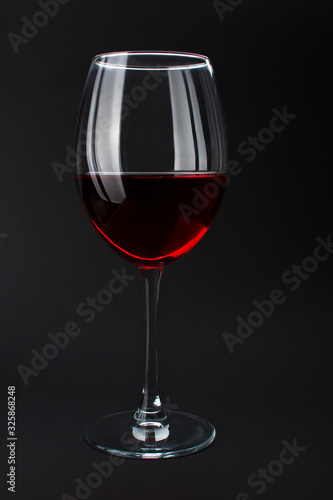 Elite red wine in beautiful glass on black background. Wine tasting and production concept, sommelier house. Luxury noblesse alcohol drink, bar and party. Alcohol addiction. Layout for design menu.